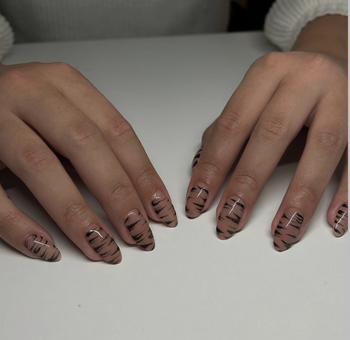 Nude almond nails with hand painted black tiger stripes