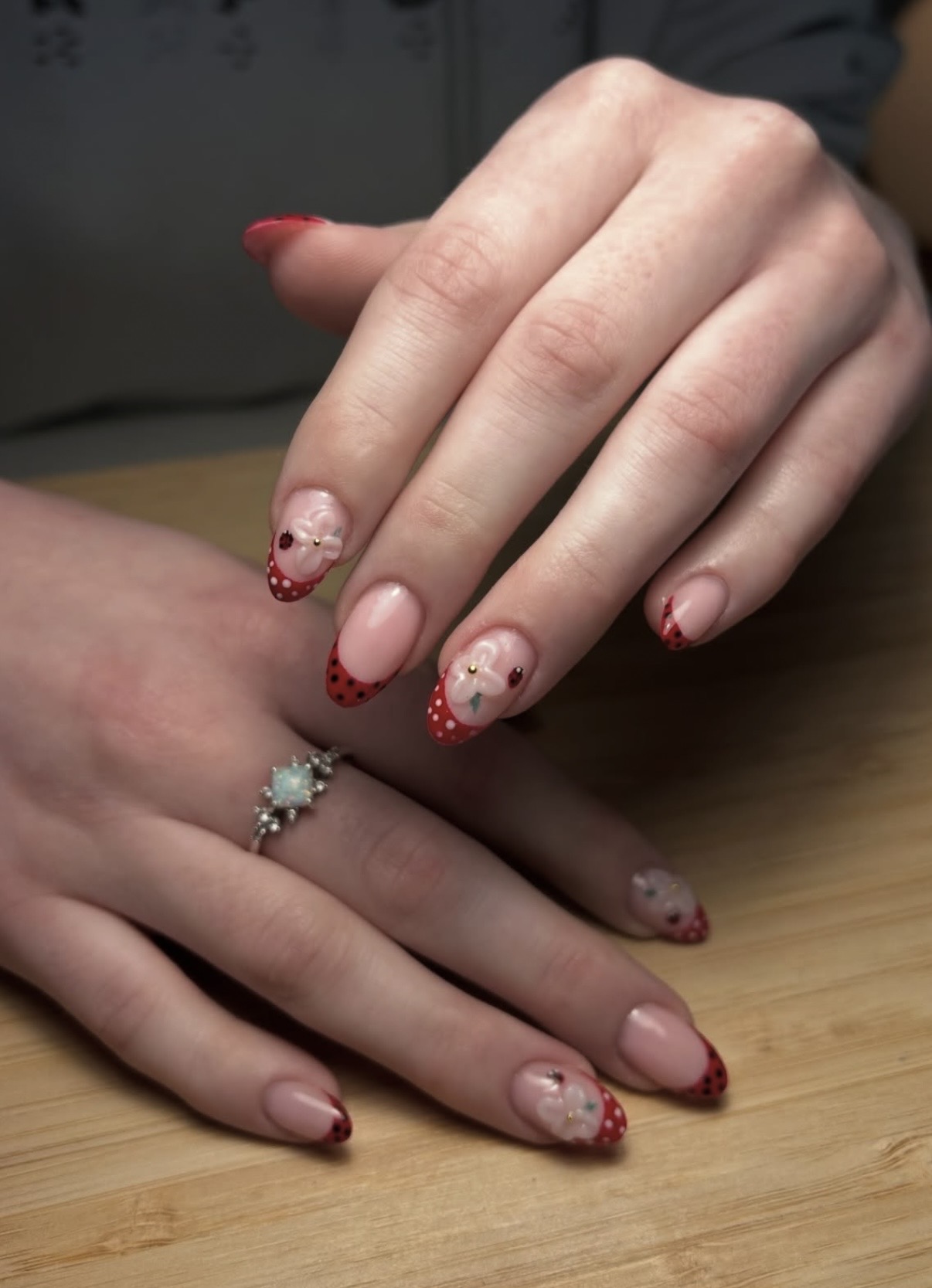 Red polka dot French nails with 3D flowers and ladybugs